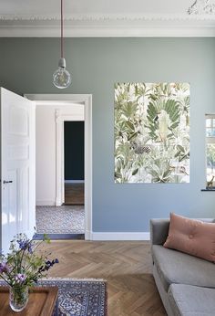 a living room filled with furniture and walls covered in wallpaper next to a doorway