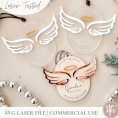 two laser cut angel wings are on top of a christmas ornament