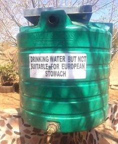 a green water tank sitting on top of a giraffe