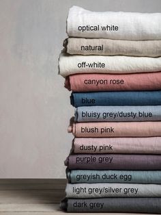 a stack of folded linens with the words optical white, off - white, canyon rose, blue, blush pink and grey on them