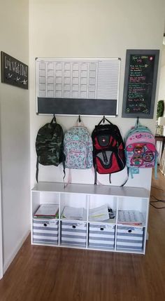 the back to school backpacks are lined up on the shelf in front of the chalkboard