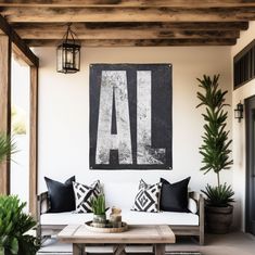 a white couch sitting on top of a wooden table next to a potted plant