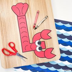 a wooden cutting board with scissors and paper cut out of it