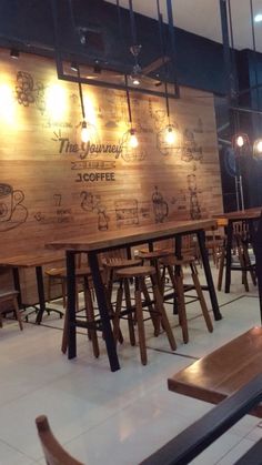 an empty restaurant with wooden tables and benches in front of the menus on the wall