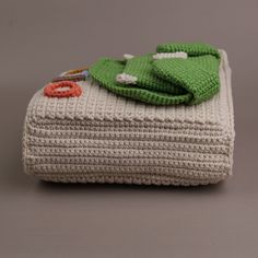 a crocheted blanket with a green frog on it