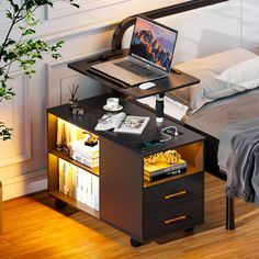 a laptop computer sitting on top of a wooden desk next to a bed with pillows