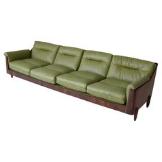 a green leather couch sitting on top of a wooden frame