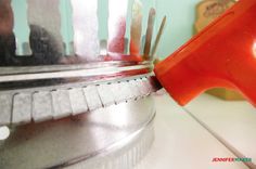 a red object sticking out of the side of a metal container on top of a white counter