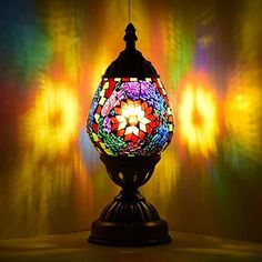 a colorful lamp sitting on top of a table next to a wall covered in multicolored lights