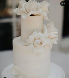 a white wedding cake with flowers on top