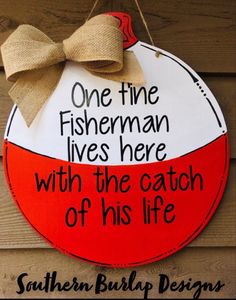 a red and white sign hanging from the side of a wooden building with a bow on it