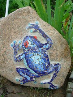 a blue frog sitting on top of a rock