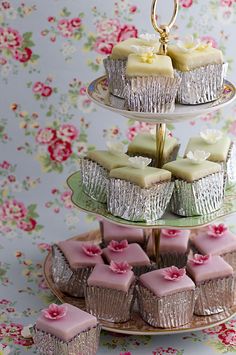 three tiered tray with cupcakes and muffins sitting on top of each other