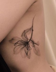 a close up of a person's thigh with a flower tattoo on the side