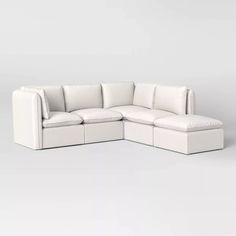 a white sectional couch sitting on top of a gray floor