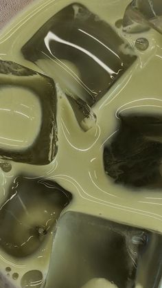 some ice cubes sitting on top of liquid in a bowl