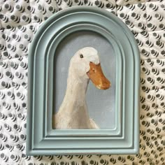 a painting of a duck in a blue frame