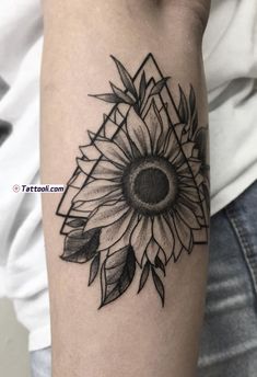 a black and white sunflower tattoo on the arm