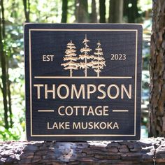 a wooden sign that says, thomas cottage lake muskka in front of some trees