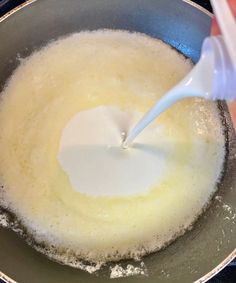 someone is pouring milk into a skillet