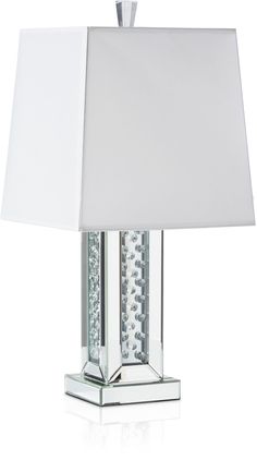 a lamp with a white shade on top of it and silver trim around the base