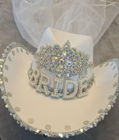 a white hat with the word bride written on it and a tiara in the shape of a cowgirl's head