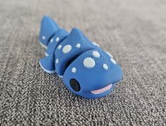 a blue toy with white polka dots on it's head laying on the ground