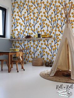 a teepee tent sitting in front of a wall with yellow trees on it