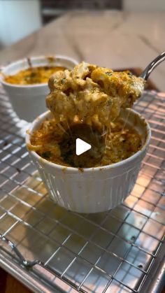 two white bowls filled with food on top of a metal rack