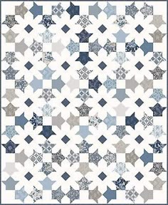 a blue and white quilt with many stars on it's sides, in the middle