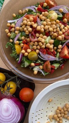 a salad with chickpeas, tomatoes, onions and lettuce on it