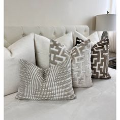 four pillows are lined up on a white couch