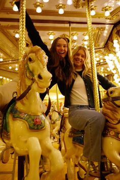 two women are sitting on a merry go round