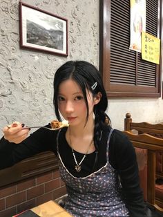 a woman sitting at a table eating food