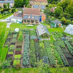 an aerial view of a vegetable garden in front of a house