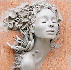 a clay sculpture of a woman with her eyes closed