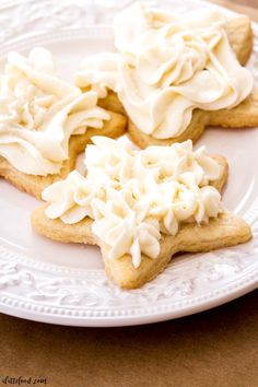 three cookies with white frosting on a plate