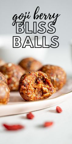 there are several balls on the plate with text overlay that says goji berry bliss balls