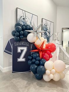 balloons and t - shirt are arranged in the shape of a football jersey on display