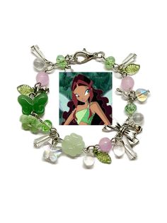 the little mermaid charm bracelet is shown with charms on it and an image of ariel