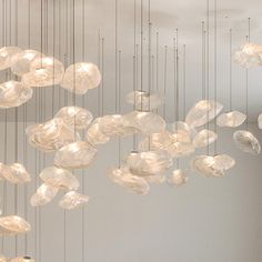 a group of lights hanging from the ceiling in a room with white walls and flooring