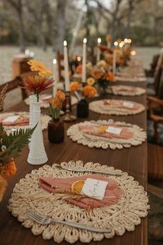 the table is set with place settings and flowers in vases, candles, and napkins