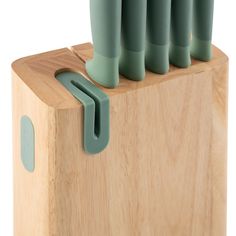 a wooden block with green handles on it and five knives sticking out of the top