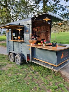 an outdoor bar on wheels in the grass