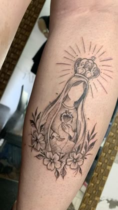 a woman's leg with a tattoo on it that has an image of the virgin mary