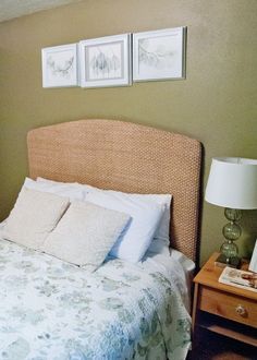 a bed with two pictures on the wall above it and a night stand next to it