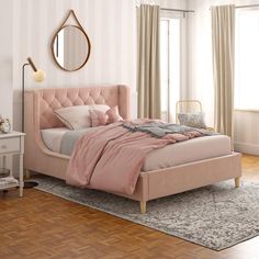 a bedroom with pink bedding and wooden floors