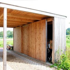 an open garage door on the side of a building with wood paneling and siding