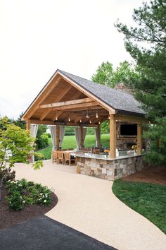 a covered patio with an outdoor kitchen and dining area