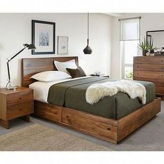 a bed room with a neatly made bed and dressers